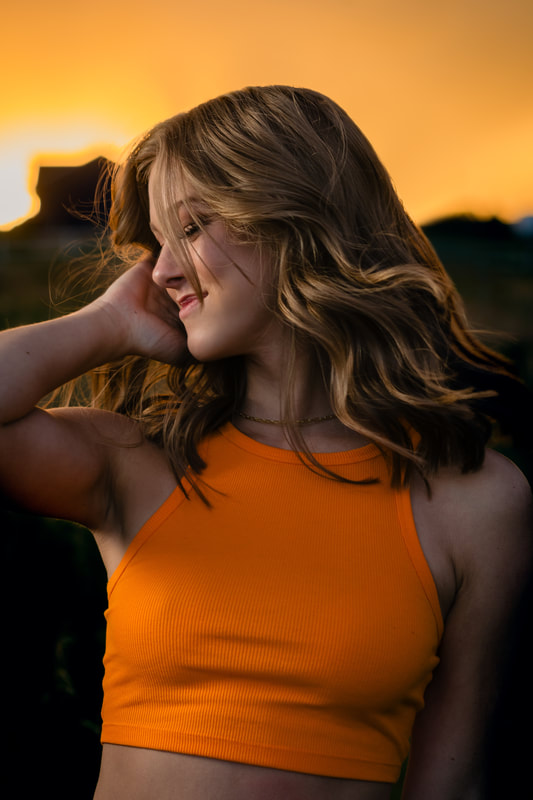 Girl in orange tank top in a field golden hour sunset senior pictures parker colorado