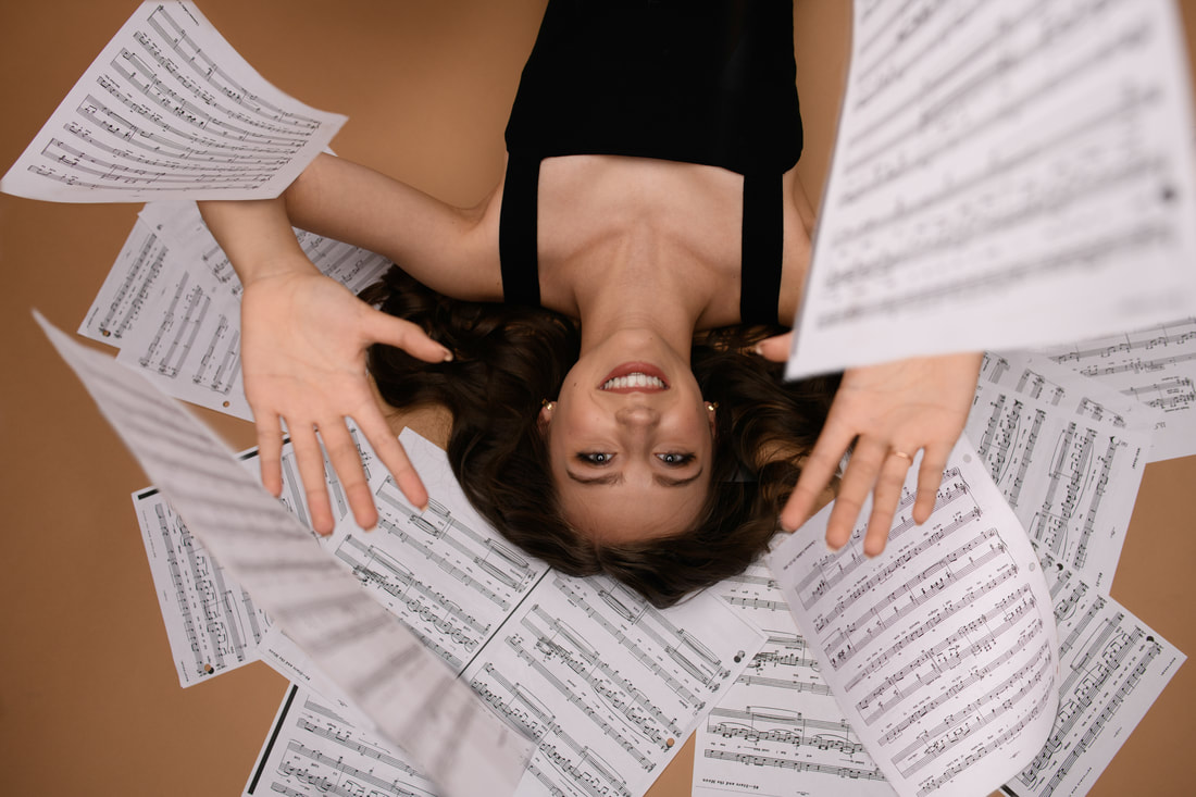 girl laying on the floor with music sheets falling around her broomfield colorado