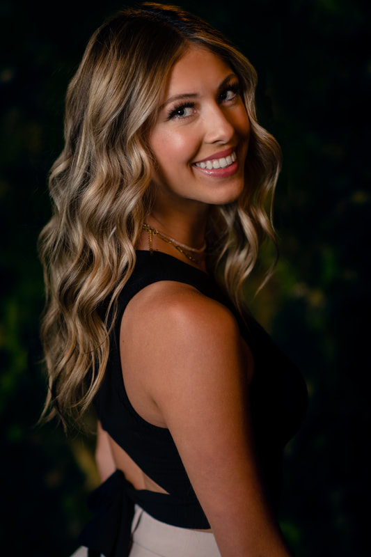 Girl in black tie shirt with beige pants and curly hair in downtown studio senior pictures inspiration sarah lindsay photography
