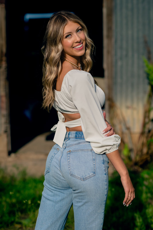 Girl in white shirt and jeans during golden hour senior photoshoot castle rock colorado